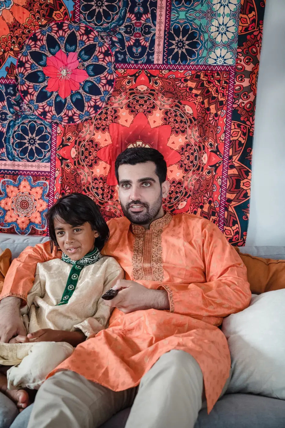 A father and son watching television together at home