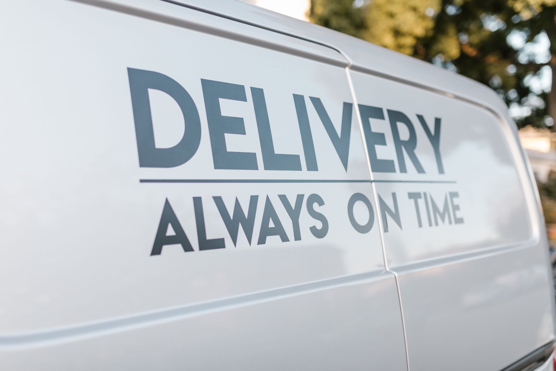 A white delivery van with large branded lettering on its side