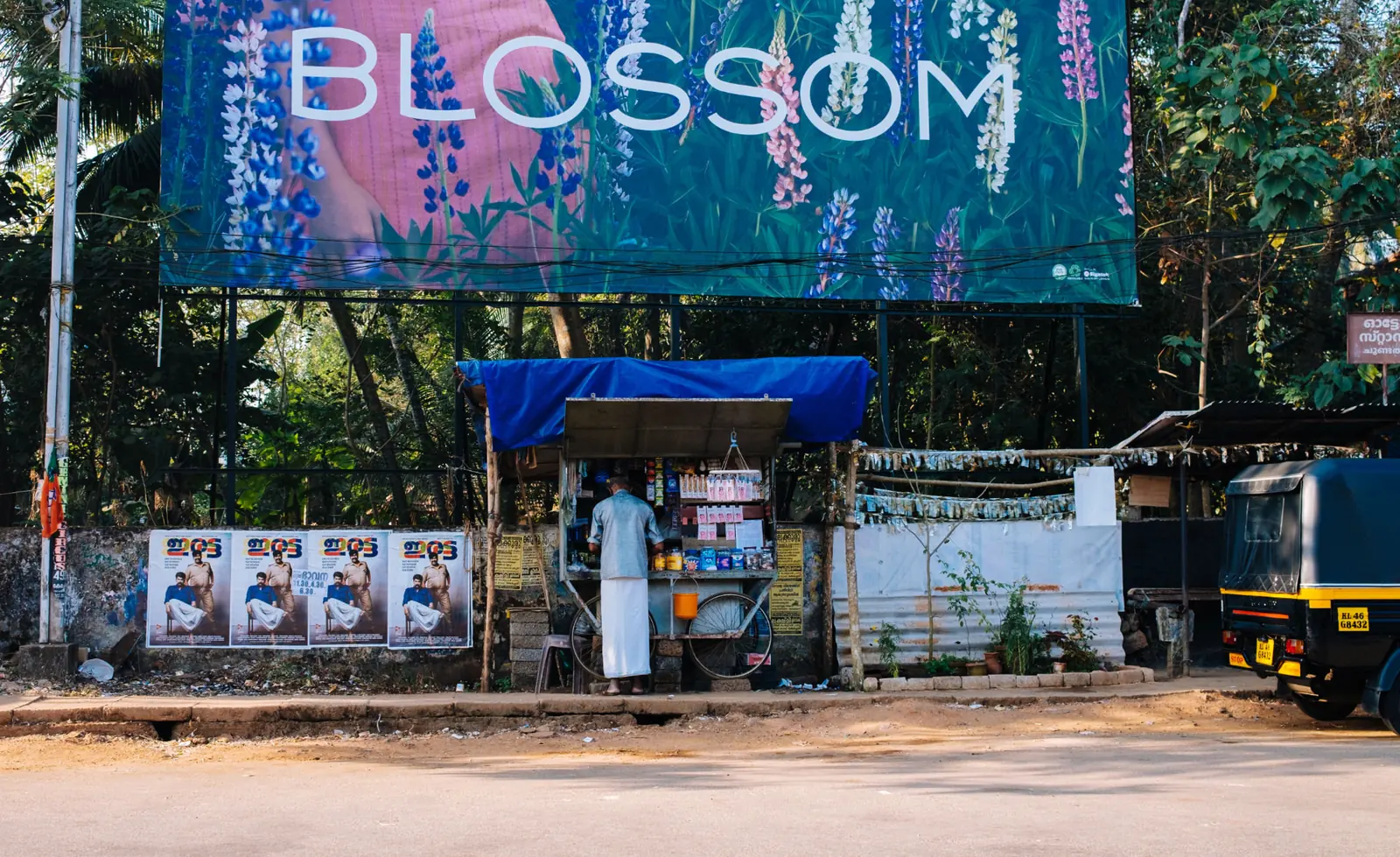 Large roadside hoarding towering over a street-side kiosk